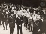 black and white photo of a group of men in uniform walking down a street