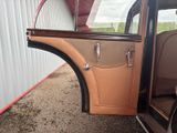 a brown car with a door open sitting in a garage