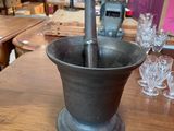 a black mortar and a red lamp on a wooden table