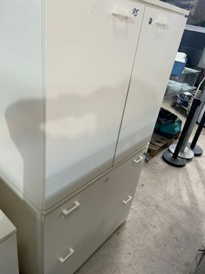 une armoire blanche à tiroirs au milieu d'une pièce