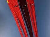 three red and black lanyards hanging on a blue wall