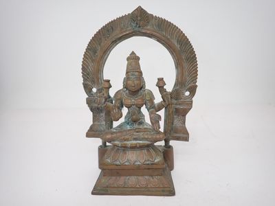 une image représentant une statue en bronze d'une femme assise sur un trône