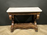 a marble top coffee table on a chevroned wood floor