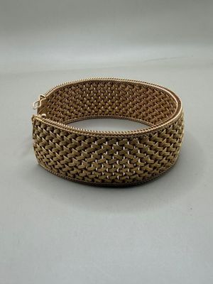 gros plan d'un bracelet en or sur une surface blanche