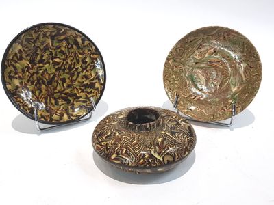 trois assiettes ornées de motifs sont posées sur une surface blanche
