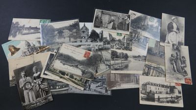 de nombreuses cartes postales anciennes représentant des personnes et des bâtiments, posées sur la table