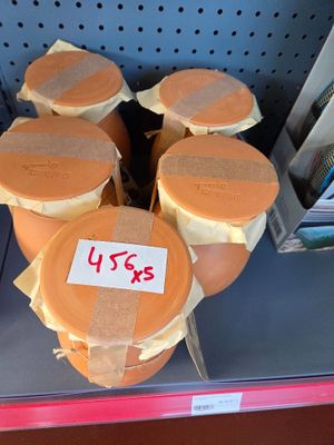 six jars of peanut butter sitting on a shelf in a store