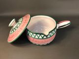 a close up of a bowl with a lid on a table