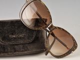 sunglasses in a case on a white surface with a gray background