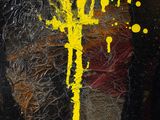 yellow paint splattered on a piece of black paper with a black background