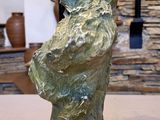 a statue of a boy holding a tennis racket on a table