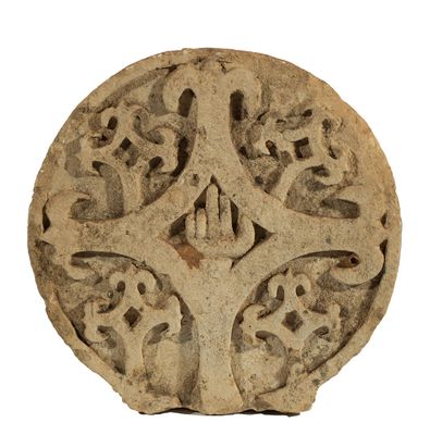 un objet en pierre orné d'un motif sur une surface blanche