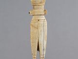 l'image d'une statue en bois représentant un homme avec un chapeau sur la tête