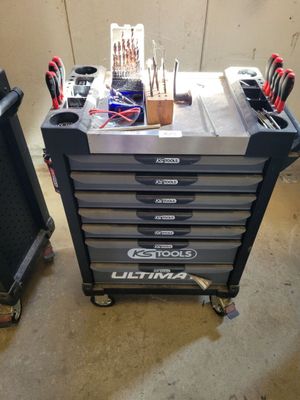 un chariot à outils avec des outils posés dessus, dans un garage