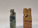 deux morceaux de pierre sculptée posés l'un à côté de l'autre sur une surface blanche