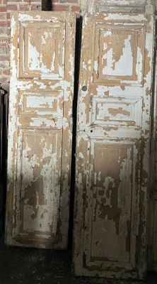 deux vieilles portes en bois dans une pièce aux murs de briques