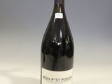 a bottle of red wine sitting on top of a white table
