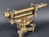an antique brass telescope on a tripod stand on a black background