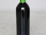 a red and green bottle of wine on a white table