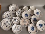 a lot of blue and white plates and bowls on the table