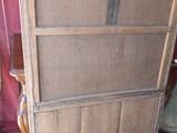 une vieille armoire en bois avec une porte vitrée, dans un coin