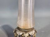 a small glass vase on a stand with a gold rim