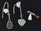 deux raquettes de tennis et un porte-clés sont posés sur une surface noire