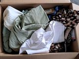 a cardboard box filled with clothes and other items