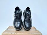 pair of black shoes sitting on top of a box on a white surface