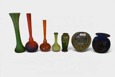 several different colored vases are lined up on a white surface