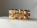a close up of a gold ring with pink and white stones