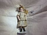 a small doll that is sitting on a white surface
