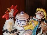 a ceramic figurine of a rooster and a girl