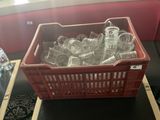 un panier rouge rempli de bouteilles en verre vides posé sur une table