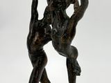 bronze statue of a man and a woman dancing on a white background