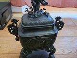 une statue en bronze représentant un oiseau perché sur un bol