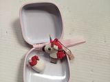 a small pink box with a small red bird in it