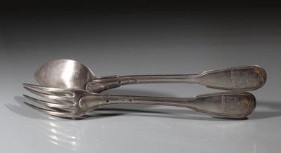 deux cuillères et une fourchette posées sur une surface blanche avec un fond noir