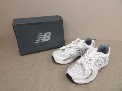 une paire de chaussures de course New Balance devant une boîte