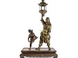 une figurine antique en bronze représentant un homme et un chien tenant une lanterne