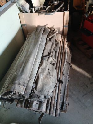 un tas de bois posé dans un garage, à côté d'un tas d'outils