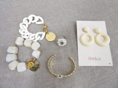 deux paires de boucles d'oreilles, un bracelet et un collier posés sur une table