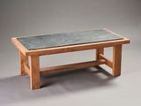 a wooden table with a slate top on a gray background