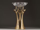 a close up of a gold vase with a glass bowl on top of it