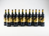 six bottles of wine lined up in a row on a white surface