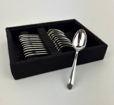 silver spoons in a black box on a white surface