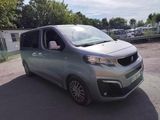 the silver van is parked in the parking lot outside of the building