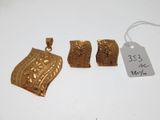 trois bijoux en or posés sur une surface blanche, accompagnés d'une étiquette de prix