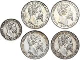 un ensemble de cinq pièces d'argent représentant des visages d'hommes et de femmes