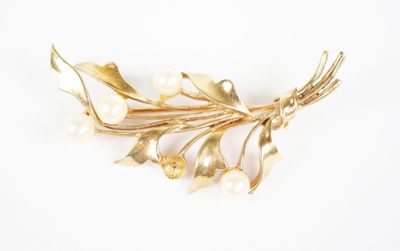 gold plated flower brooch with pearls on a white background